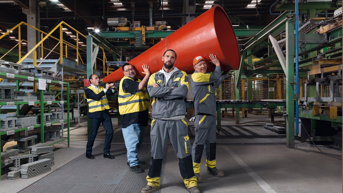 Betriebsratsteam Hauptwerk der Ziegelproduktionsfirma Wienerberger Österreich GmbH Das 4-köpfige Team des Betriebsrat steht in einer Betriebshalle. Sie halten zu dritt ein übergroßes Megaphon, während der Vorsitzende, Georg Huber, mit verschränkten Armen im Vordergrund steht.