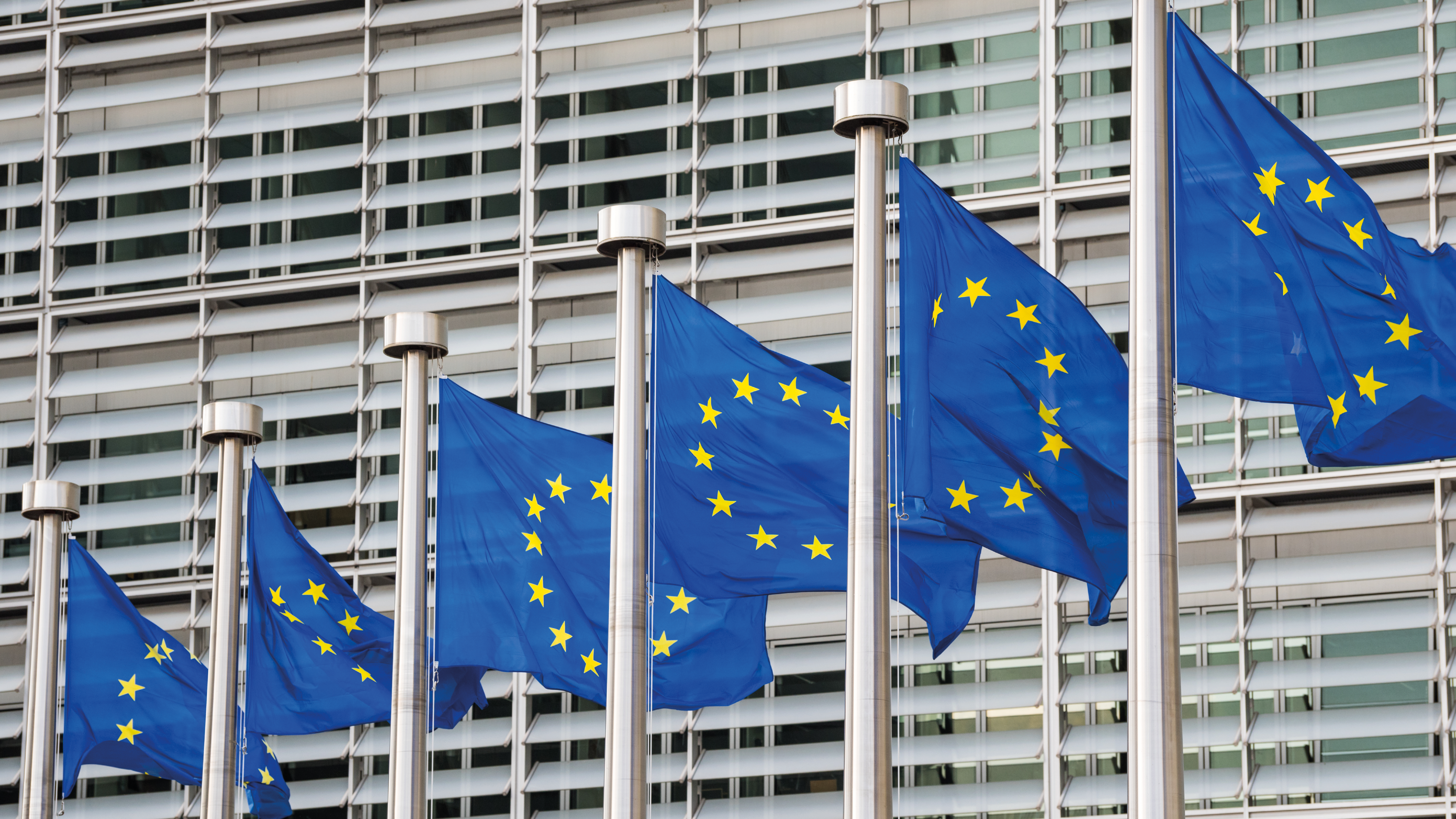 Vor dem Berlaymont-Gebäude in Brüssel, dem Sitz der Europäischen Kommission, wehen mehrere EU-Fahnen im Wind