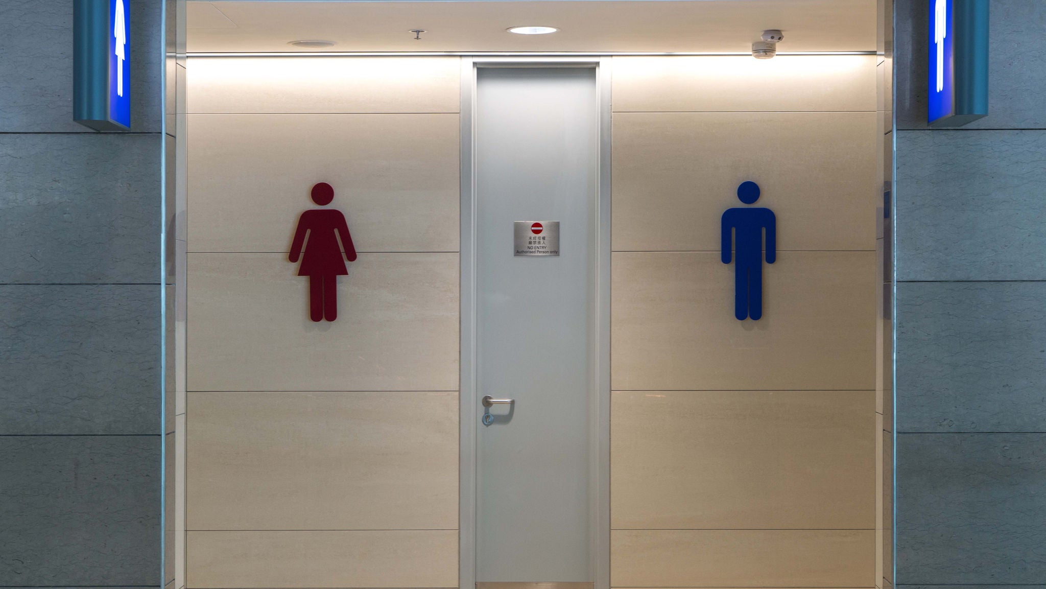 Vorderansicht einer öffentlichen Toilette mit Mann- und Frauenschild.