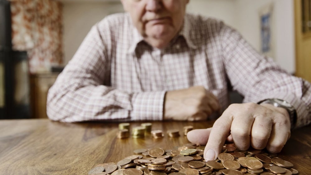 Älterer Herr zählt Münzen
