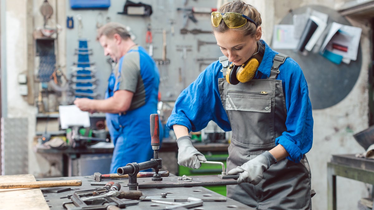Man and woman working together in metal workshop Man and woman working together in metal workshop