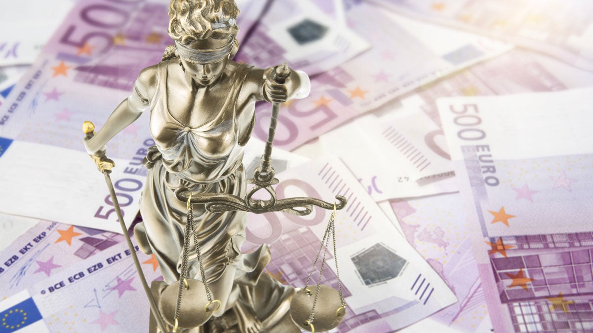 Justitia steht auf einem Haufen Geldscheinen