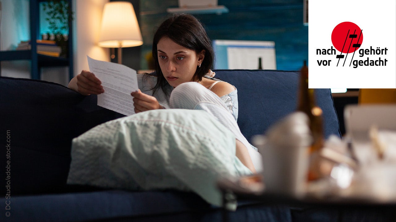 Frau liest sehr besorgt ein Dokument am Sofa zuhause - könnte ein Banlauszug sein 