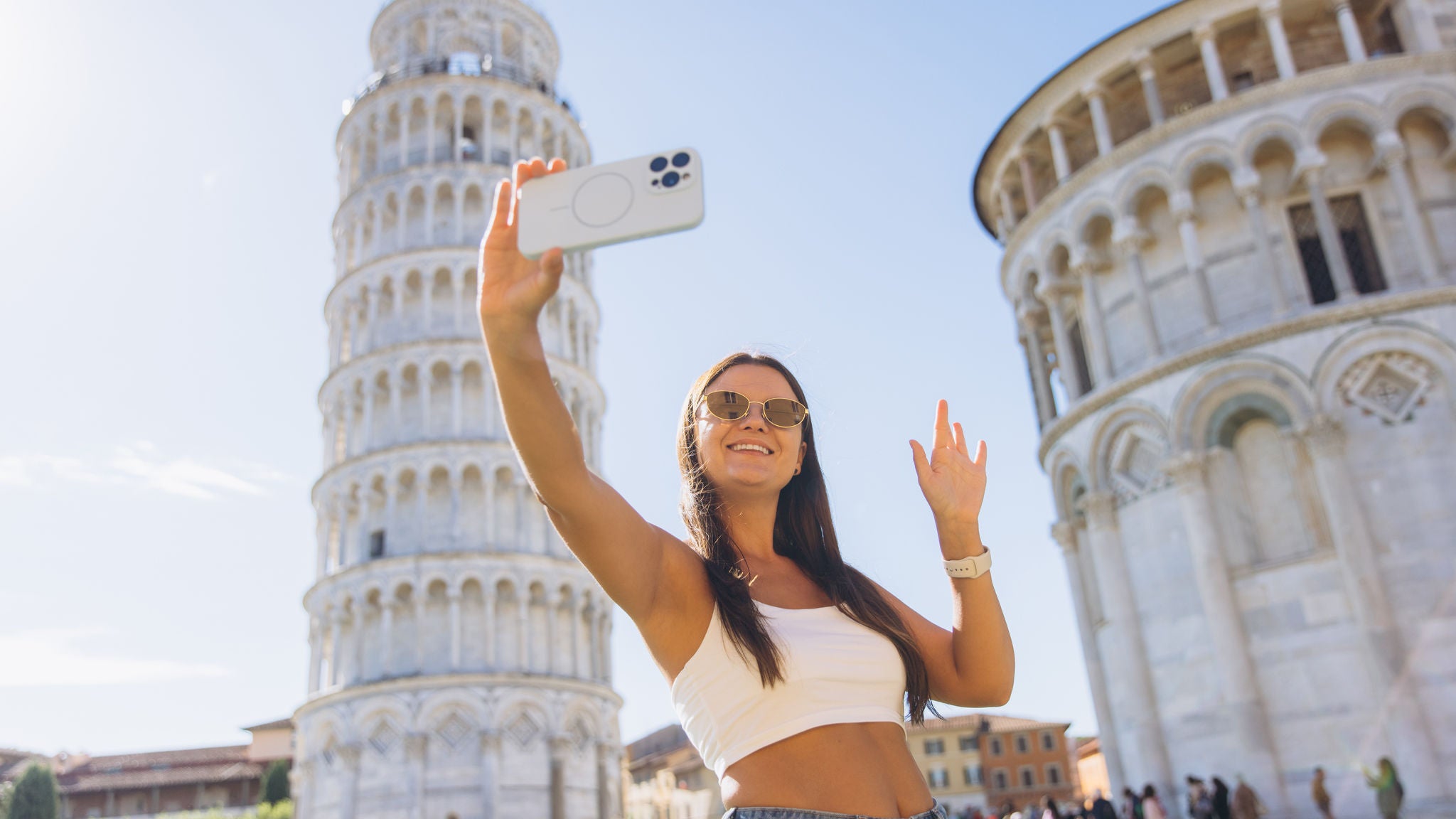 Frau macht ein Selfie vor dem Schiefen Turm von Pisa.
