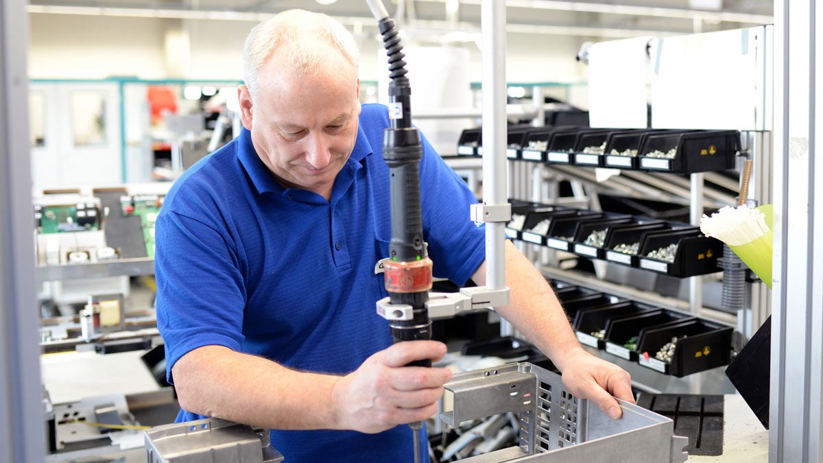 älter Arbeiter montiert Bauteile in Fabrik