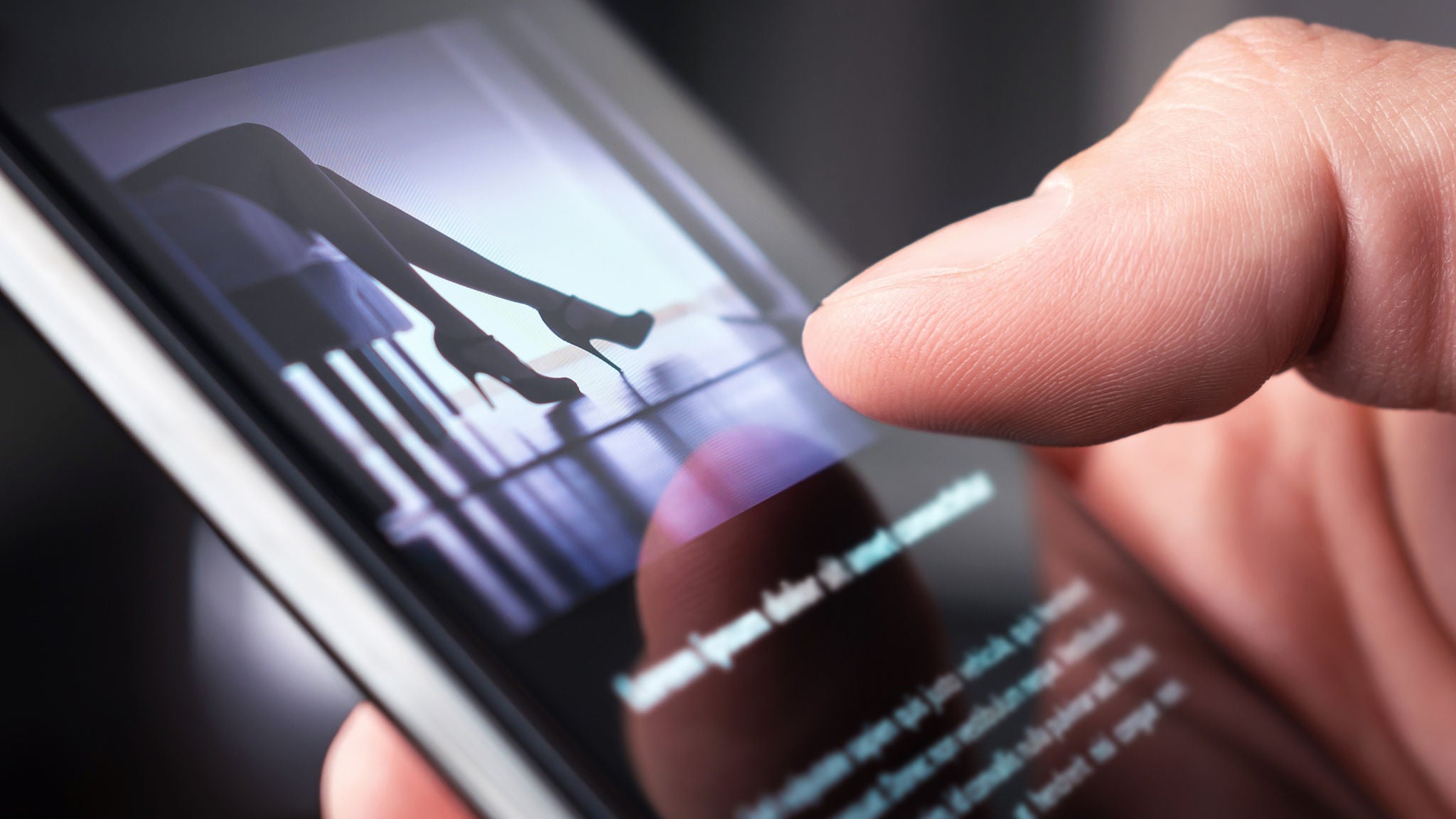 Ein Mann schaut sich ein erotisches Video an oder betrachtet ein sexy Foto auf dem Handy. Sexshop oder Online-Porno-Webseite. Eine Person liest einen Nachrichtenartikel über ein sexuelles Thema. Escort-Service, Strip-Show oder Erwachseneninhalte im Internet.