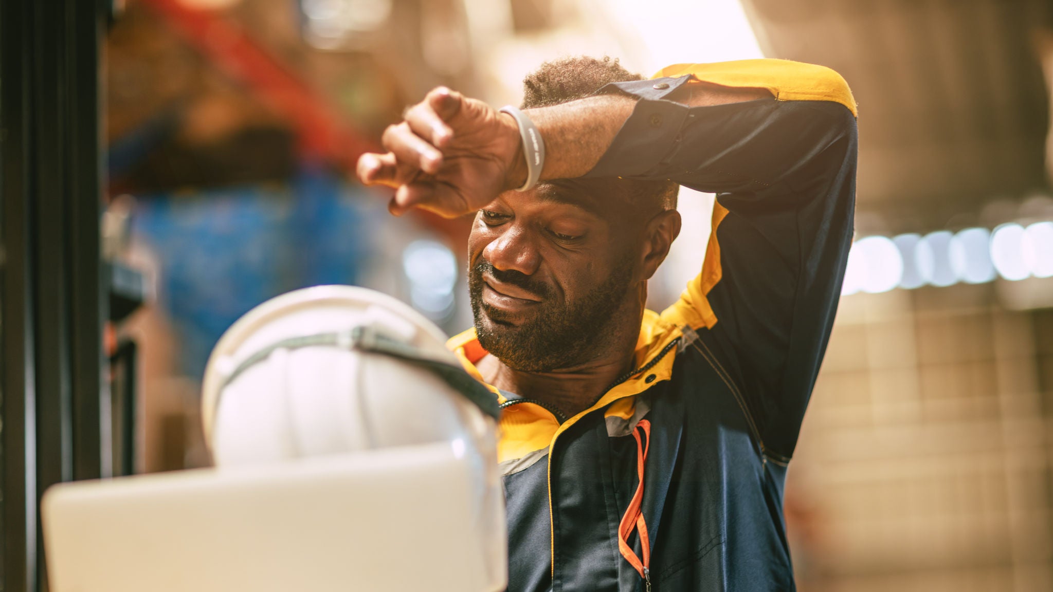 African black male worker tired stressed sweat from hot weather in summer working indoor warehouse