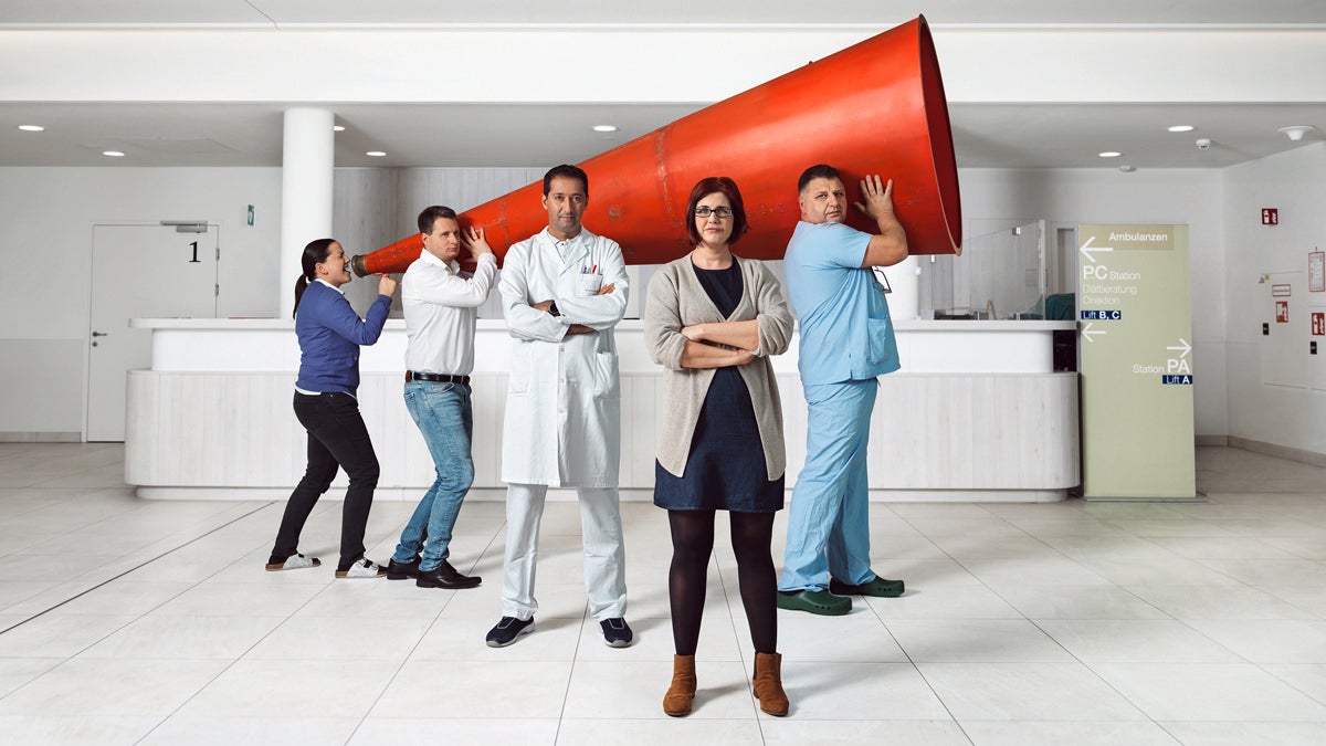 Gruppenfoto eines fünfköpfigen Betriebsratsteam die ein zwei Meter Sprachrohr halten