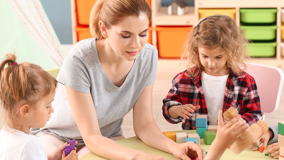 Nursery teacher with cute little children in kindergarten Nursery teacher with cute little children in kindergarten