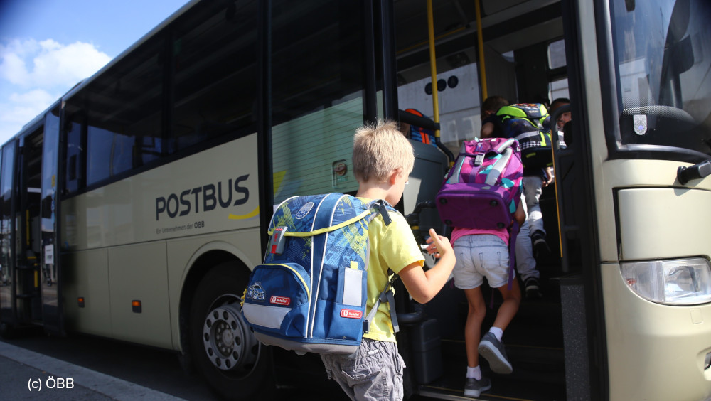 Schulkinder beim Einsteigen in einen Postbus