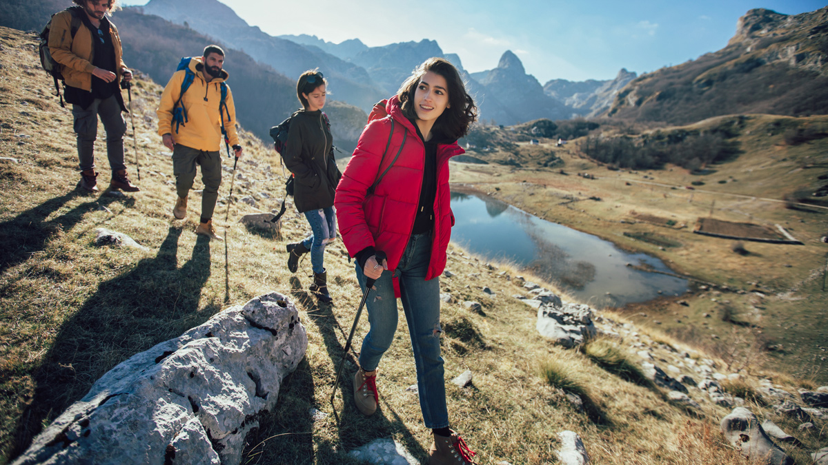 Gruppe junger Menschen wandert im Herbst am Berg. 