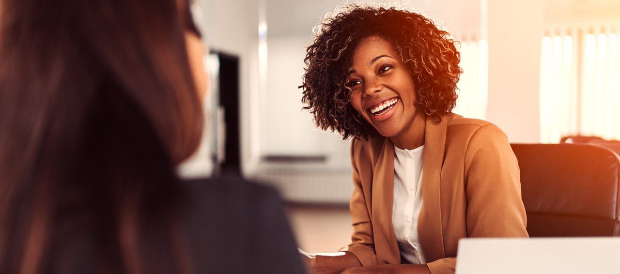 Happy young busiensswoman discussing at the meeting with his colleague