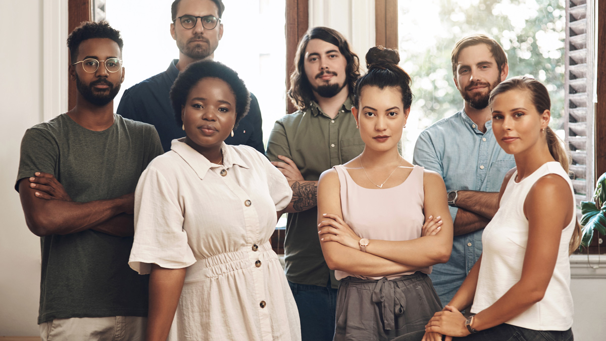 Serious business people standing with arms crossed, looking confident and showing teamwork in an office together at work. Portrait of diverse creative employees expressing power, unity and success
